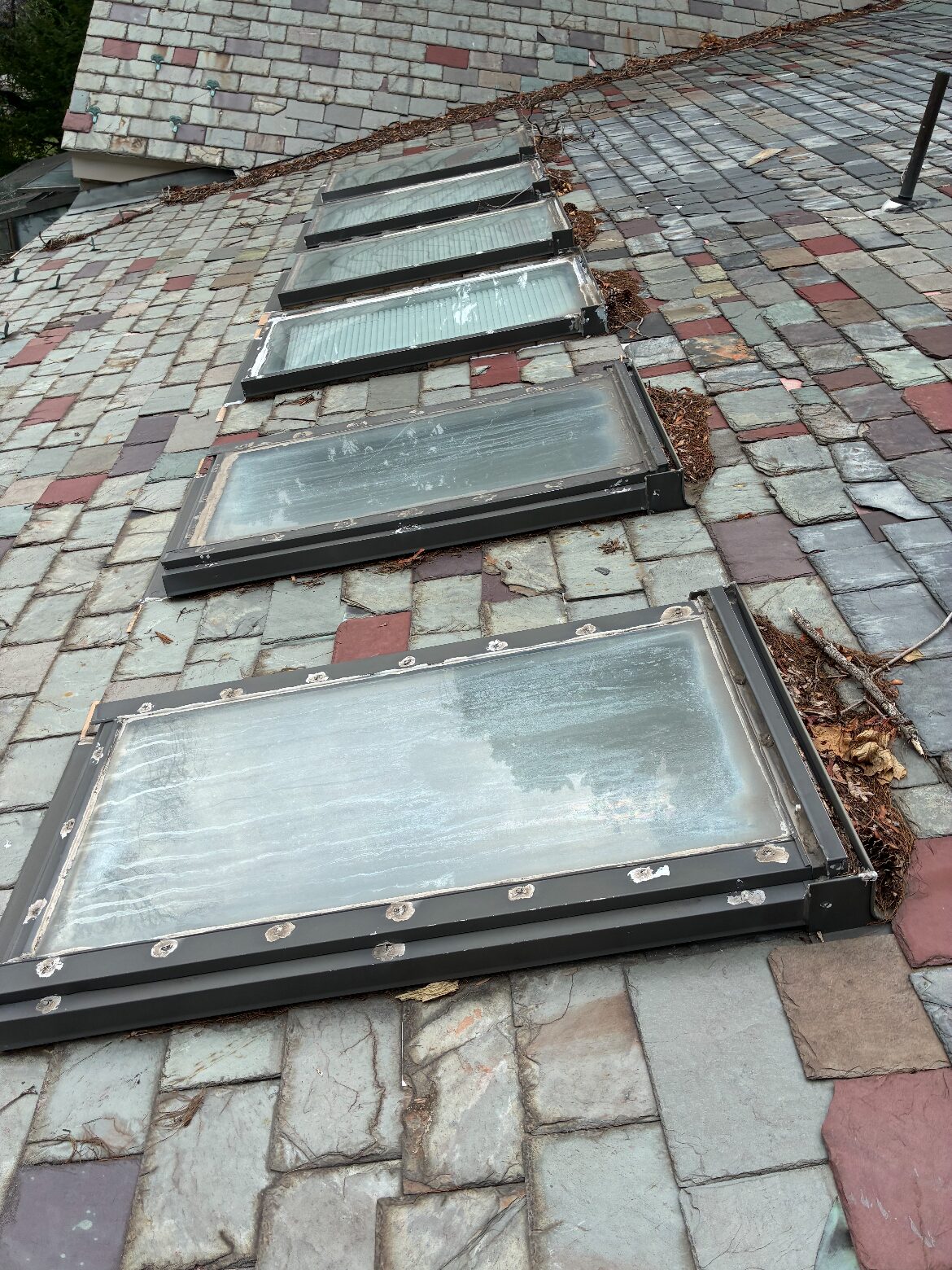 Old fogged skylights on a slate roof before replacement — Be Shore Exteriors